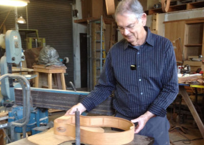John examines the sides of the guitar under construction